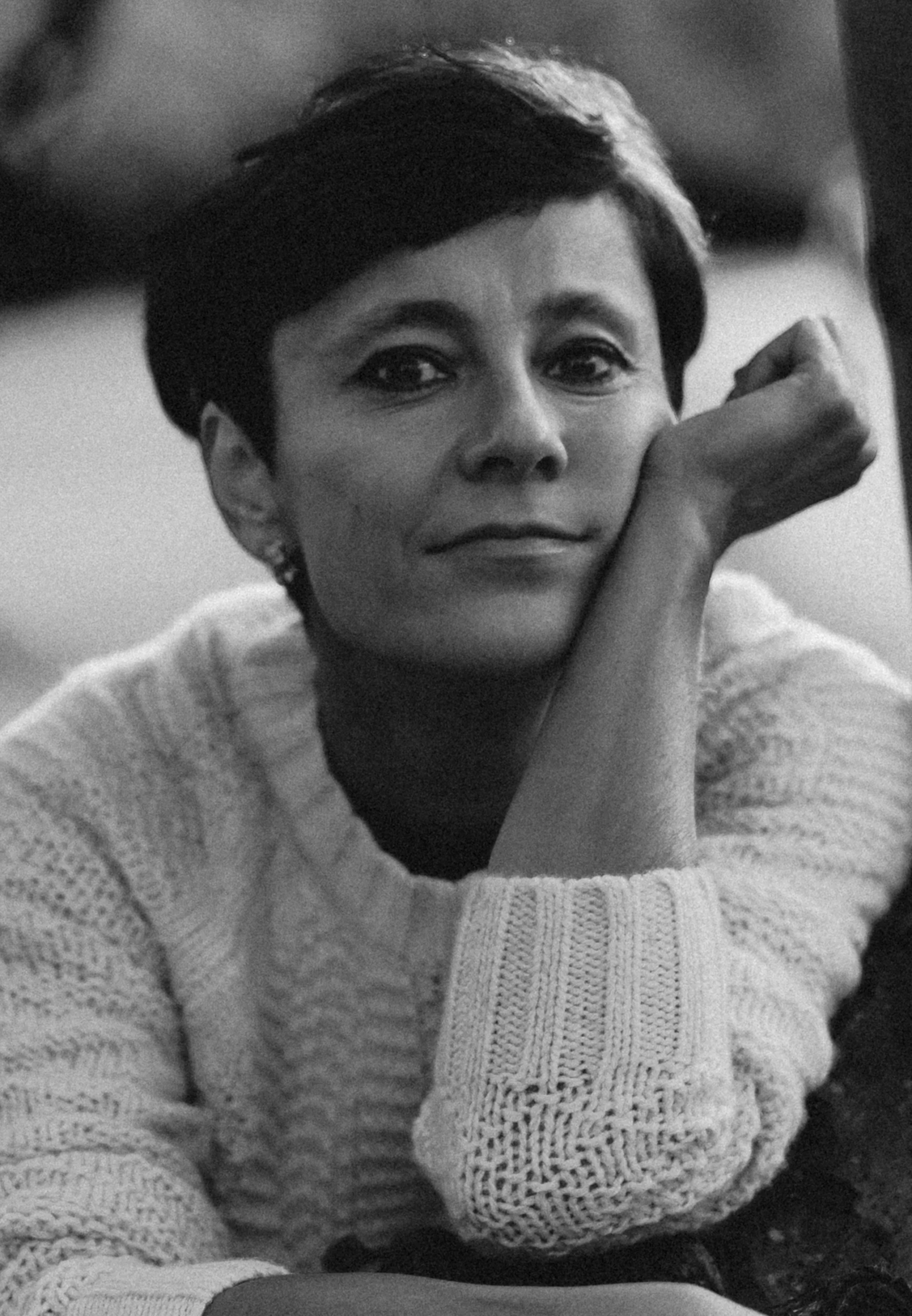 Black and white portrait of Irina Dmitrieva resting her chin on her hand, looking directly at the camera with a calm and open expression.