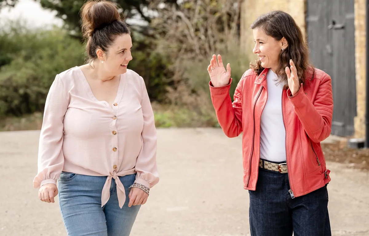 Irina Dmitrieva walking outdoors and talking with a coaching client