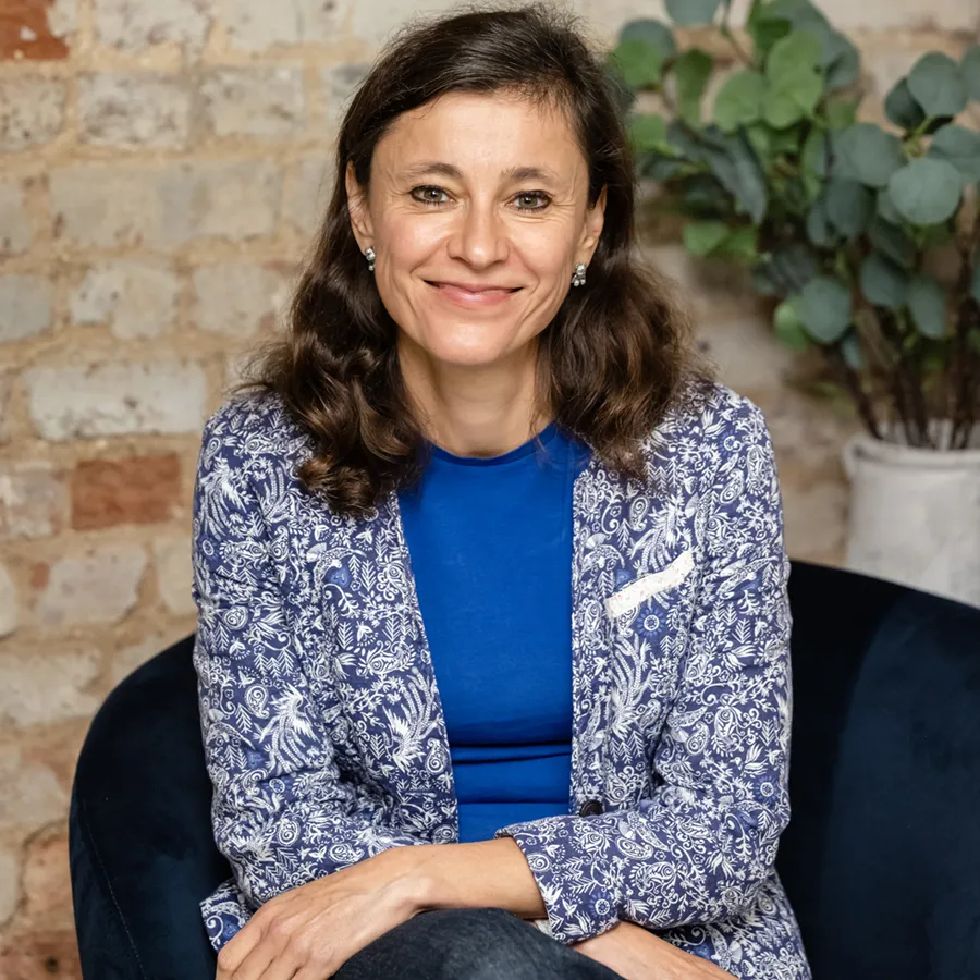 Irina Dmitrieva seated and smiling in a relaxed portrait