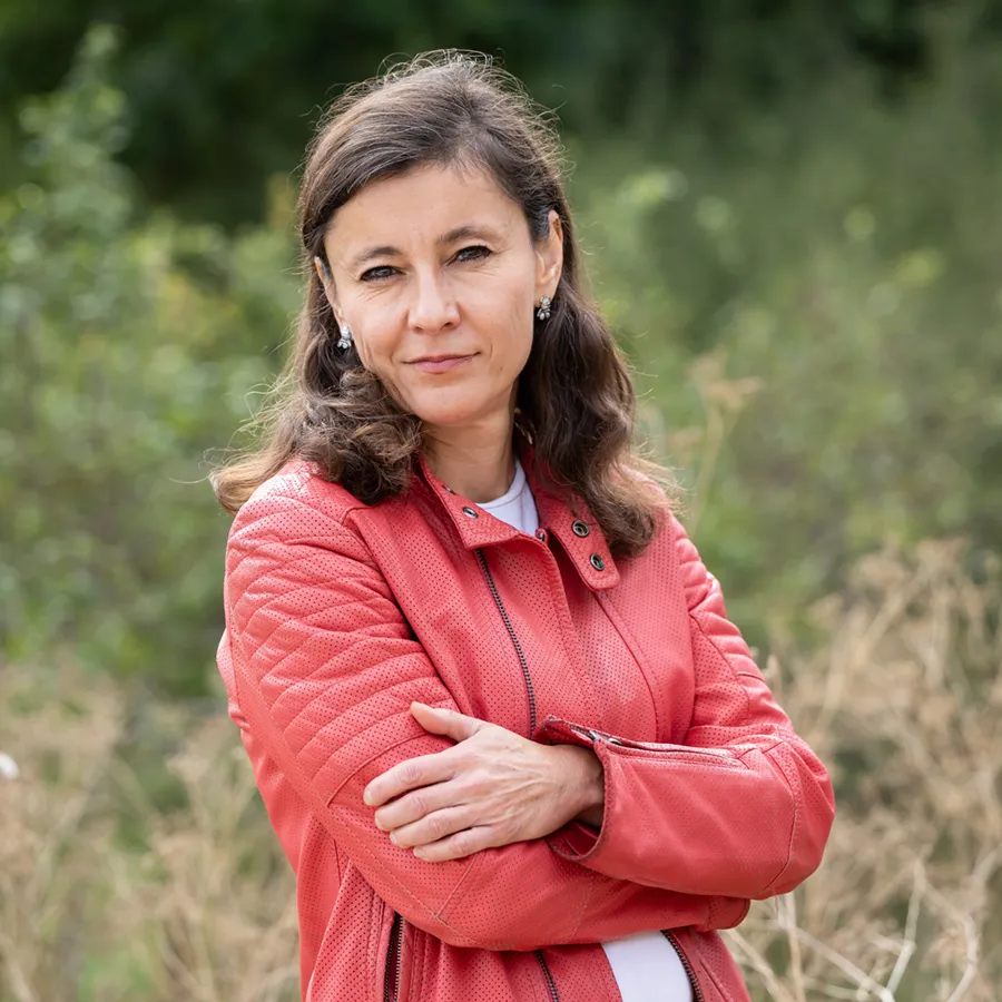 Irina Dmitrieva smiling outdoors in a red jacket