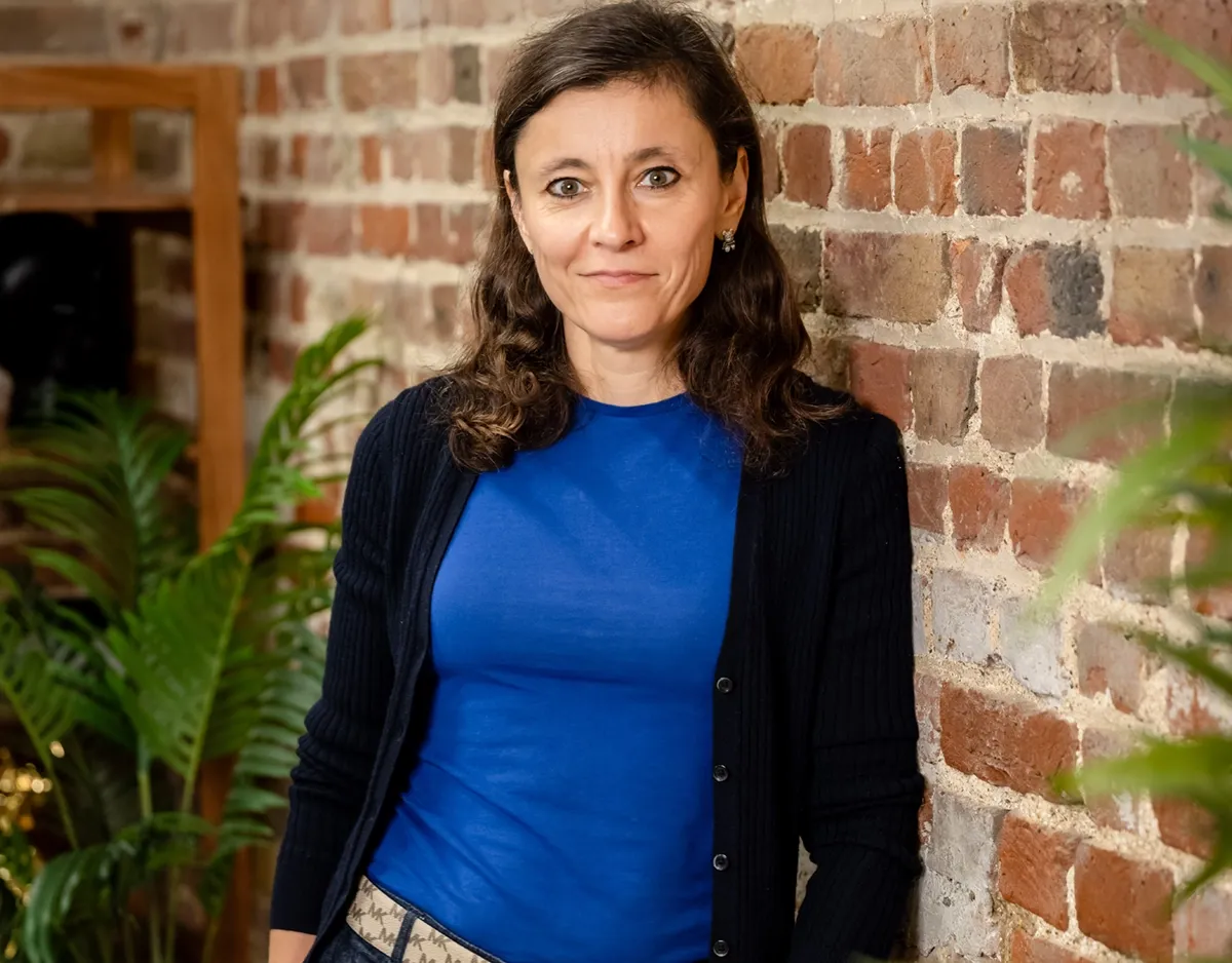 Career coach Irina Dmitrieva standing beside a brick wall